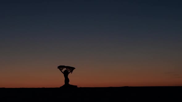 Girl Is Dancing Belly Dancing Against the Beautiful Sunset on the Beach. Silhouettes