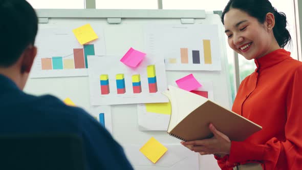 Young Woman Explains Business Data on White Board