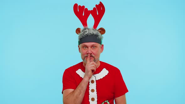 Man Wears Red Christmas Tshirt Presses Index Finger to Lips Makes Silence Gesture Sign Secret