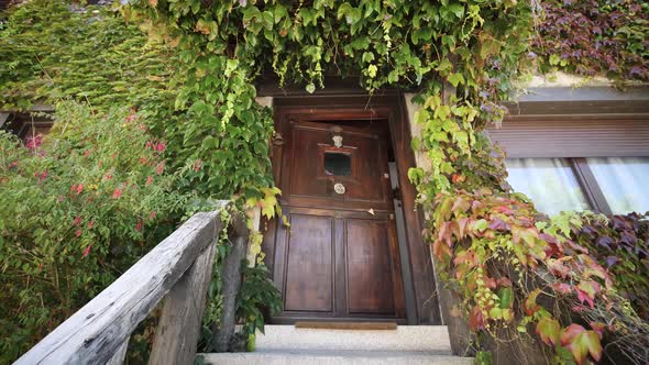 wooden house door entry with plants and autumn colors in residential middle class building