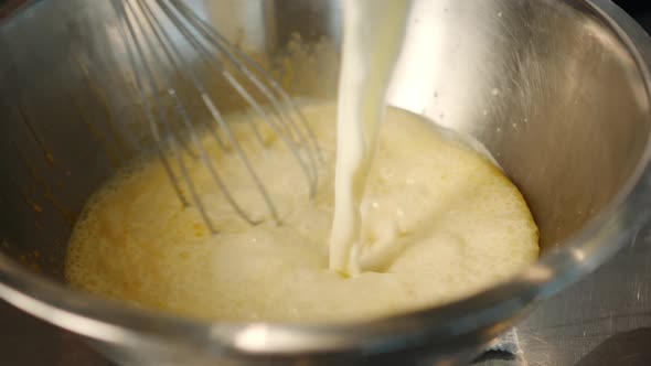 Milk is churned in a professional restaurant kitchen. Dessert cooking.