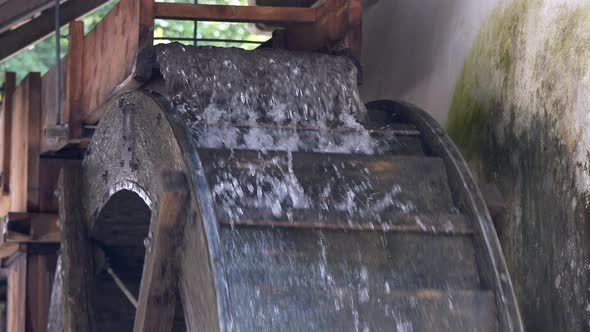 Slow motion close up of rotating wooden watermill in mountains