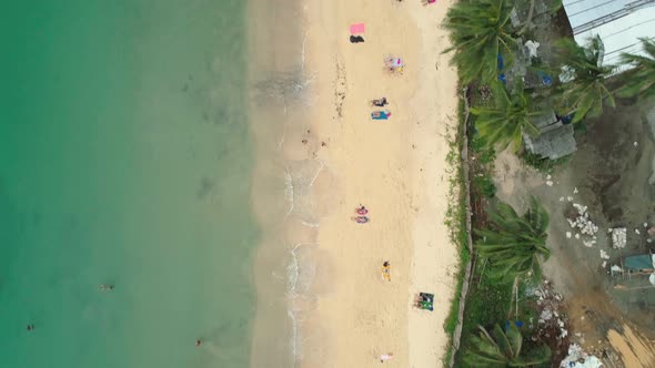 Beautiful bird's eye aerial view of Las Cabanas beach in El Nido, Philippines. People are enjoying a