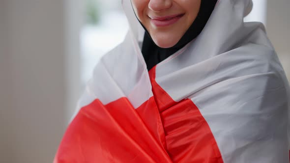 Unrecognizable Young Woman in Hijab Wrapping in Canadian Flag Smiling