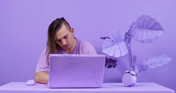 Young Freelancer Gets Tired Working on Laptop at Table