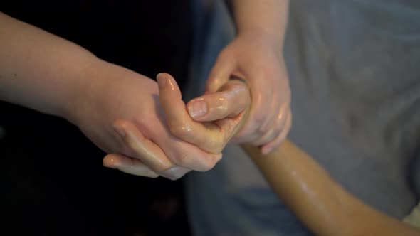 Massage therapist massages a beautiful mature woman’s hand. Steadicam shot.