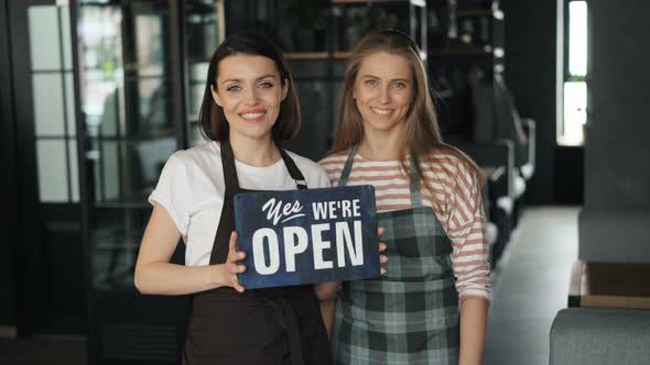 Portrait of Beautiful Business Owners Holding Open Sign in Cafe Smiling