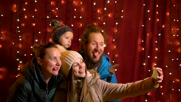 Daughter taking selfie with family at Christmas market.