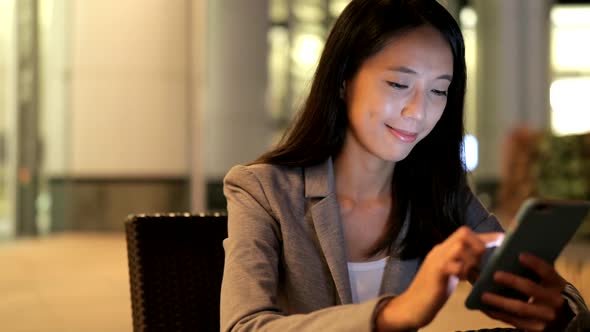 Business woman using smart phone in city at night 