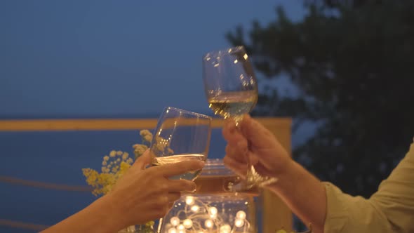 Clinking Wine Glasses on Terrace by Lake