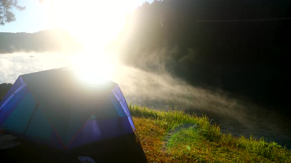 Camping Tent Near Mist River in Nature Background with Sunrise Scenic View