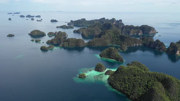 Areal shot over the beautiful lagoon of Misool. blue water with turquoise spots where coral reefs ar