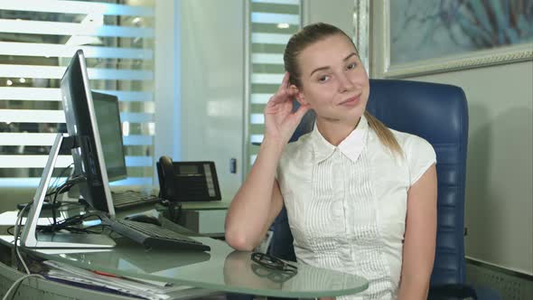 Portrait of Woman Sitting in Busy Creative Office Looking at Camera