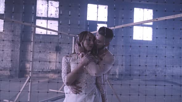 Couple Dancing Behind a Mesh Fence