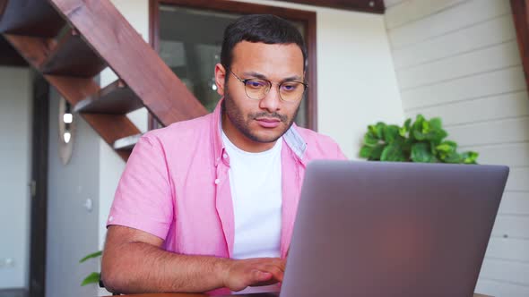 Man Using Laptop Typing Keyboard Having Video Conference at Home Office