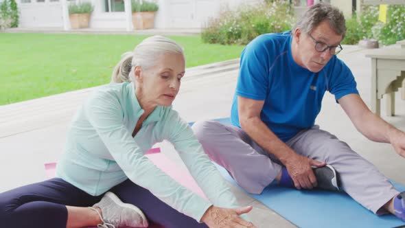 Senior couple exercising in a garden