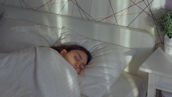 Brunette Caucasian Female Woman Sleeping in White Bed in the Morning Sunlight