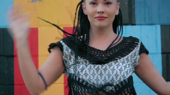 Dancing Female. happy mixed race woman dancing performance with long dreadlocks in shorts