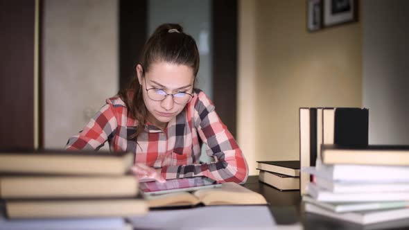 The girl uses a tablet and the Internet to search for the necessary information