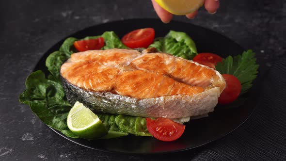 Close Up of Female Hand Sprinkling a Lemon Juice on Prepared Salmon Steak