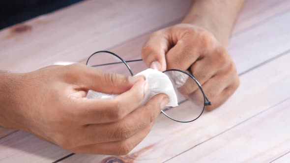 Close Up of Man Hand Cleaning Eyeglass