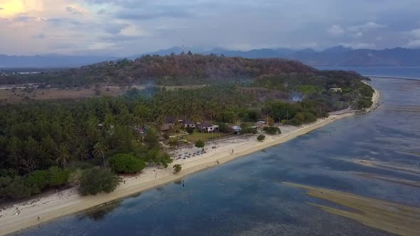 Chilling on the beach under palm trees on a small island Smooth aerial view flight fly forwards sin