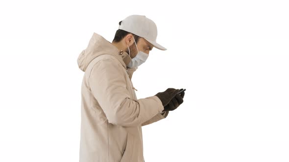 Caucasian Man in a Medical Mask Walking and Using the Phone on White Background