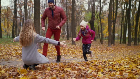 Beautiful Mother Embracing Her Familiy in Autumn