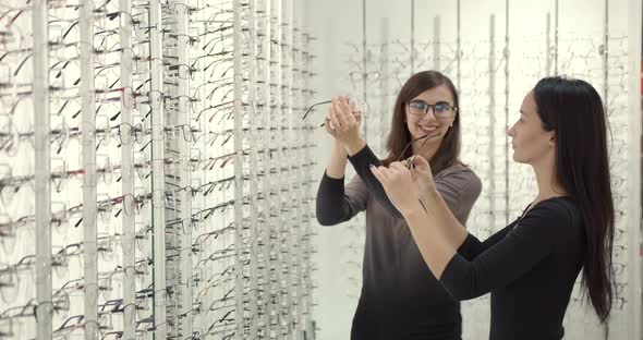 Woman Chooses Glasses with a Consultant at Optician's