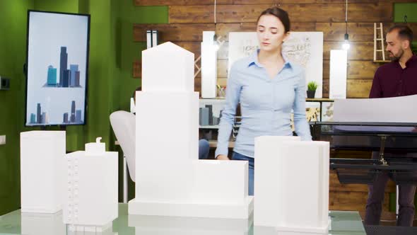 Young Female Architect Taking Photos of Building Models