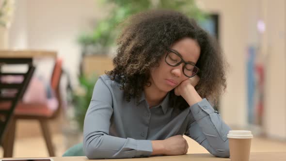 Young African Woman Taking Nap at Work