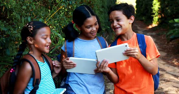 Kids using digital tablet in park