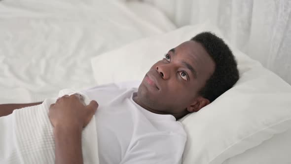 Worried African Man Awake in Bed
