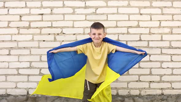 smiling adorable Ukrainian boy is happy with the victory of his country. children against war.