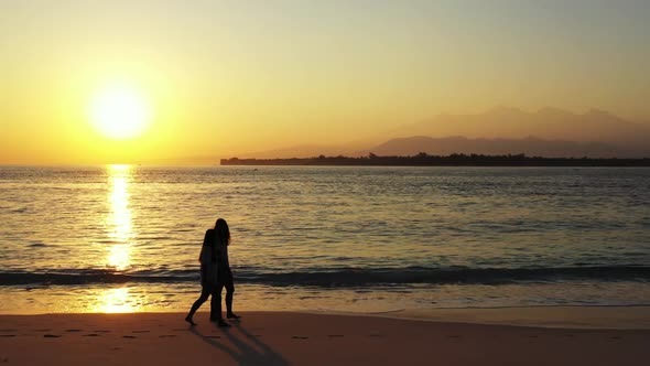 Ladies together happy and smiling on marine lagoon beach time by blue green sea and bright sandy bac