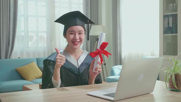 Excited Asian Woman Holding A University Certificate, Smiling And Thumb Up To Camera