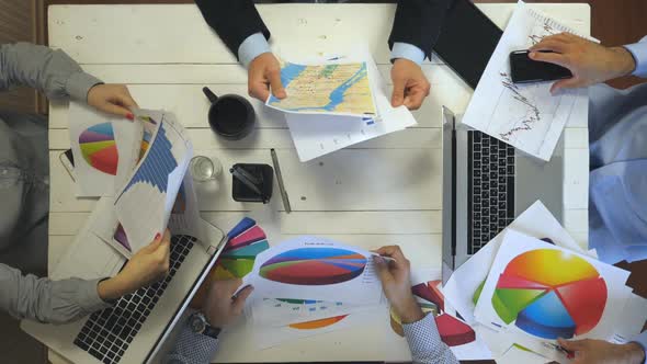 Hands Business People Sitting at Table in Trendy Office and Examining Graphs