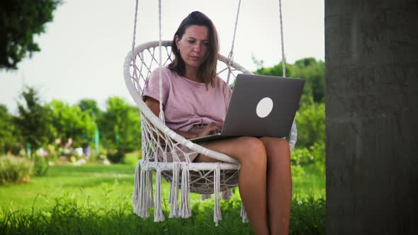 Woman Works In Garden Swing Chair