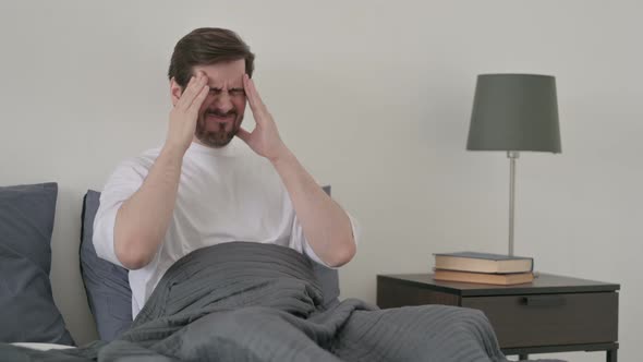 Young Man Having Headache While Sleeping in Bed