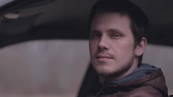 Portrait of attractive young man in the car.