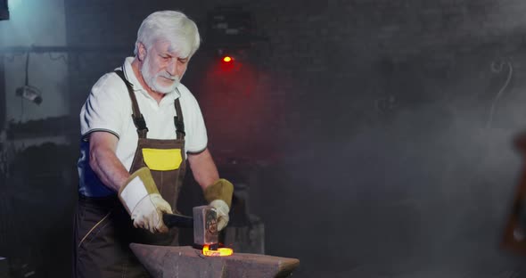 Old Male with Grey Hair and Beard Working in Smithy