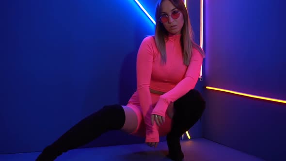 Fashionable Girl in Pink Clothes on The Background of Neon Lamps