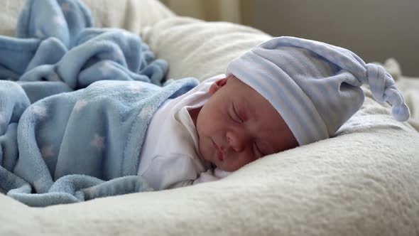 Closeup Newborn Baby Face Portrait Early Days Sleeping Sweetly On Tummy Blue White Background