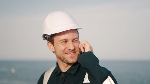 Young Happy Marine Deck Officer Talking with Family or Friends on Mobile Phone Amd Smiling