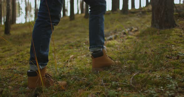 Man Walks Along the Mountains To the Top. Tourist in Boots Going Along the Stone Road on the