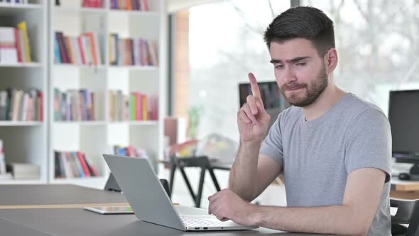 No Finger Sign By Young Man with Laptop in Office