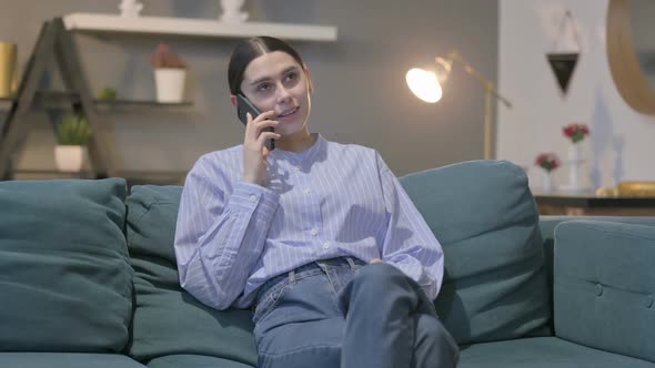 Hispanic Woman Talking on Phone on Sofa