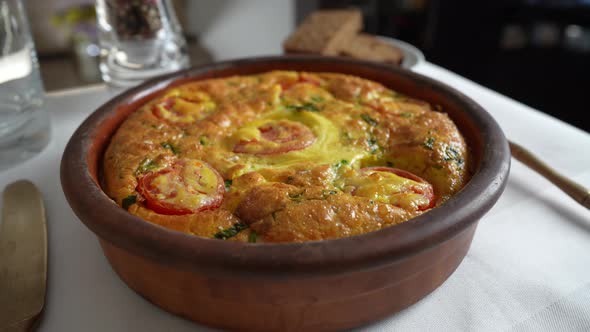 Vegetable frittata with egg, tomato, pepper, onion, cheese and green wild garlic