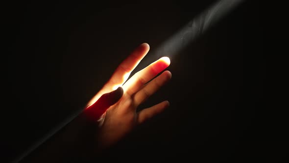 Woman's Fingers Touching a Beam of Light