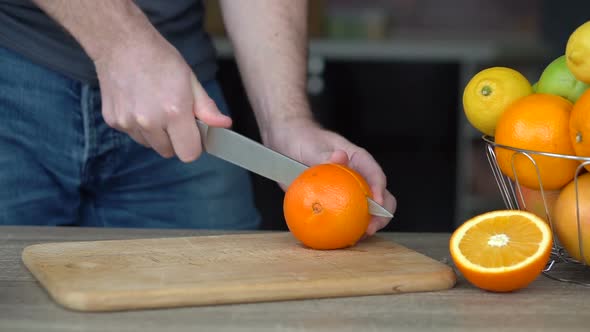 Male Hands are Cutting Ripe Orange for Making Citrus Juice  Healthy Lifestyle Fruit Juice
